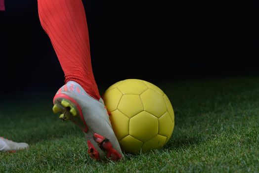 soccer player doing kick with ball on football stadium  field  isolated on black background