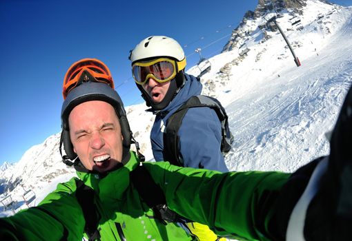 happy people group have fun on ski snow at winter season on mountain with blue sky and fresh air