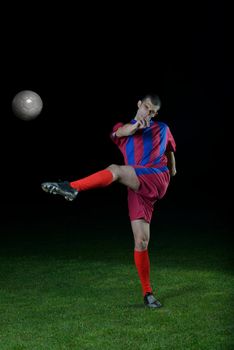 soccer player doing kick with ball on football stadium  field  isolated on black background