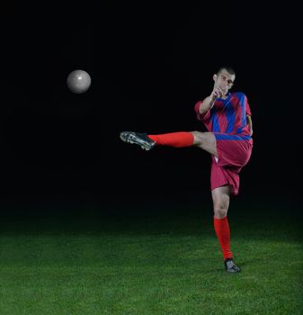 soccer player doing kick with ball on football stadium  field  isolated on black background