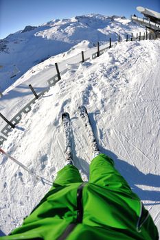 skier skiing downhill on fresh powder snow  with sun and mountains in background