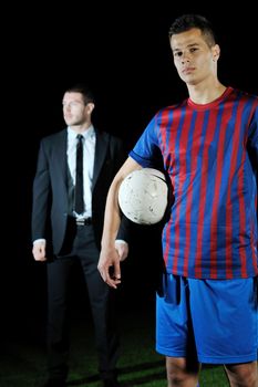 soccer  sport manager in business suit coach and football player on stadium with green grass and white ball