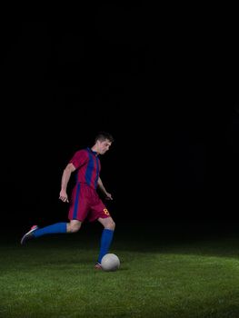 soccer player doing kick with ball on football stadium  field  isolated on black background