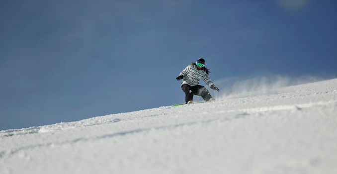 snowboard woman racing downhill slope and freeride on powder snow at winter season and sunny day