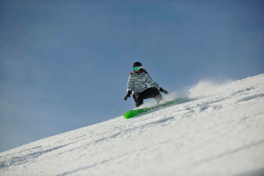 snowboard woman racing downhill slope and freeride on powder snow at winter season and sunny day