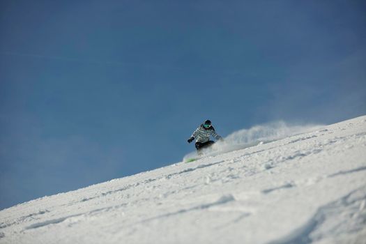 snowboard woman racing downhill slope and freeride on powder snow at winter season and sunny day