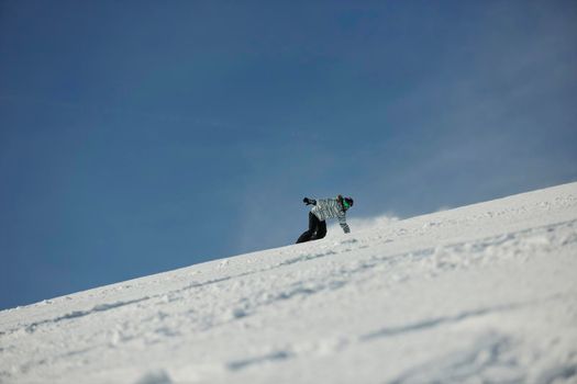 snowboard woman racing downhill slope and freeride on powder snow at winter season and sunny day