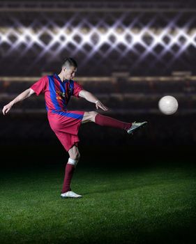 soccer player doing kick with ball on football stadium field
