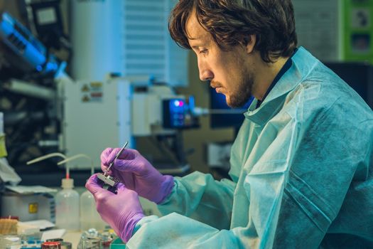 Scientist in a laboratory prepare a sample for an elecron microscopic investigation.