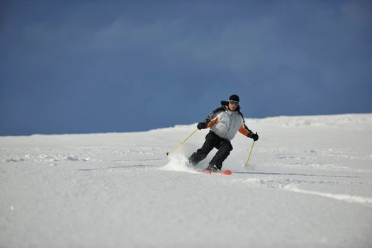 skier free ride downhill at winter season on beautiful sunny day 