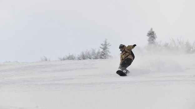 freestyle snowboarder jump and ride free style  at sunny winter day on mountain