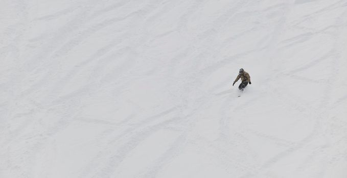 freestyle snowboarder jump and ride free style  at sunny winter day on mountain