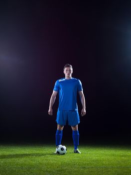 soccer player doing kick with ball on football stadium  field  isolated on black background