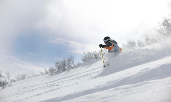 man ski free ride downhill at winter season on beautiful sunny day and powder snow