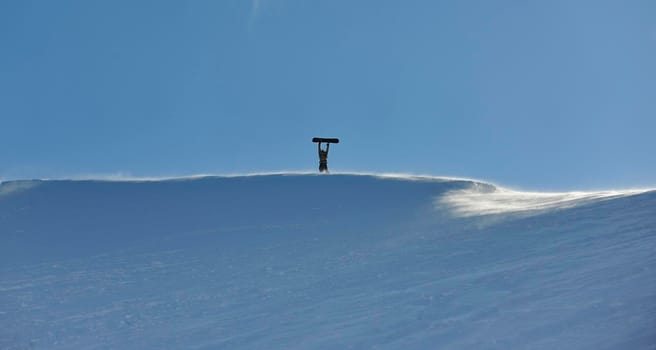 snowboarder relaxing and posing at sunny day on winter season with blue sky in background