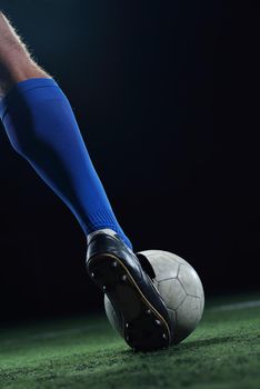 soccer player doing kick with ball on football stadium  field  isolated on black background