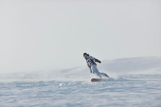 freestyle snowboarder jump and ride free style  at sunny winter day on mountain