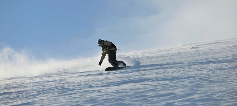 freestyle snowboarder jump and ride free style  at sunny winter day on mountain