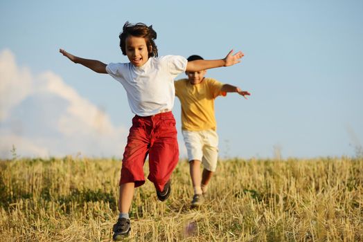 Happy children running on beautiful field