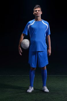 soccer player doing kick with ball on football stadium  field  isolated on black background