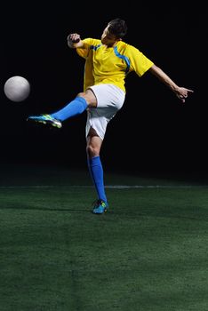 soccer player doing kick with ball on football stadium  field  isolated on black background