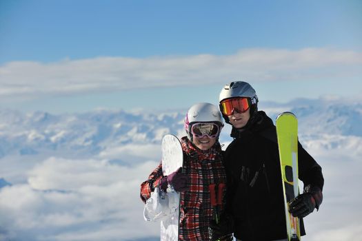 happy people group have fun on snow at winter season on mountain with blue sky and fresh air