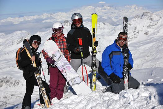 happy people group have fun on snow at winter season on mountain with blue sky and fresh air