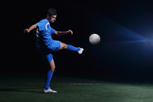 soccer player doing kick with ball on football stadium  field  isolated on black background