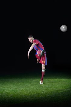 soccer player doing kick with ball on football stadium  field  isolated on black background