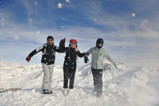 happy people group have fun on snow at winter season on mountain with blue sky and fresh air