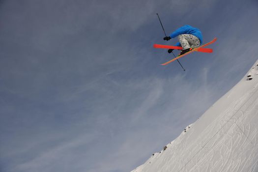 extreme freestyle ski jump with young man at mountain in snow park at winter season