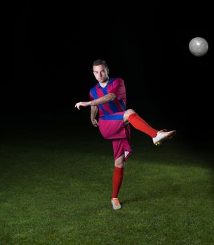 soccer player doing kick with ball on football stadium  field  isolated on black background