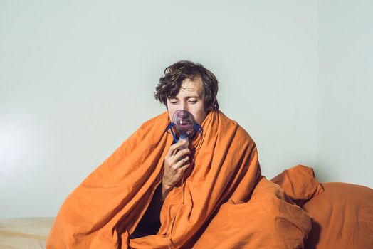 man with flu or cold symptoms making inhalation with nebulizer - medical inhalation therapy.