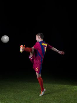 soccer player doing kick with ball on football stadium  field  isolated on black background