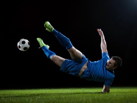 soccer player doing kick with ball on football stadium  field  isolated on black background