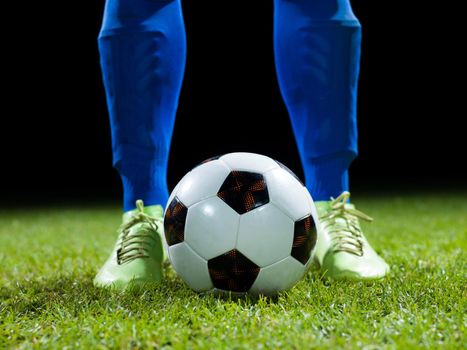 soccer player doing kick with ball on football stadium  field  isolated on black background