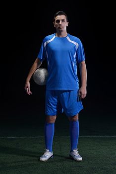 soccer player doing kick with ball on football stadium  field  isolated on black background