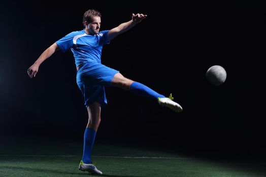 soccer player doing kick with ball on football stadium  field  isolated on black background