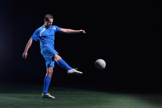 soccer player doing kick with ball on football stadium  field  isolated on black background