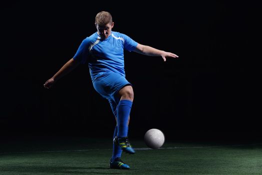 soccer player doing kick with ball on football stadium  field  isolated on black background