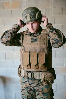 soldier preparing tactical protective and communication gear for action battle