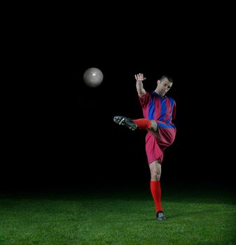 soccer player doing kick with ball on football stadium  field  isolated on black background