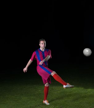 soccer player doing kick with ball on football stadium  field  isolated on black background