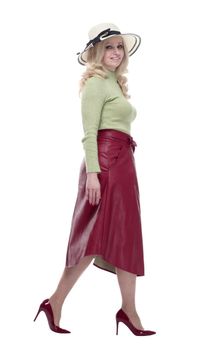 in full growth. smiling woman in a summer hat striding forward . isolated on a white background