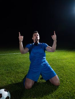 soccer player doing kick with ball on football stadium  field  isolated on black background