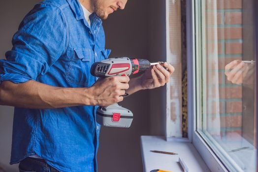 Man in a blue shirt does window installation.