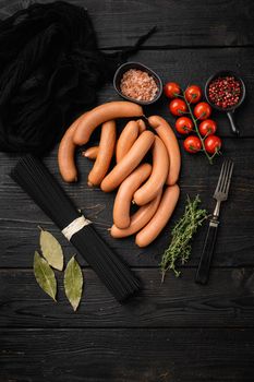 Classic boiled meat pork sausages set, on black wooden table background, top view flat lay