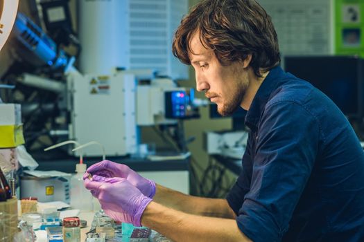 Scientist in a laboratory prepare a sample for an elecron microscopic investigation.