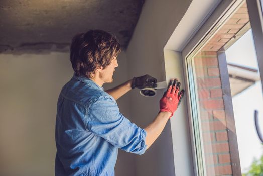 Man in a blue shirt does window installation.