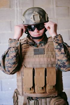 soldier preparing tactical protective and communication gear for action battle